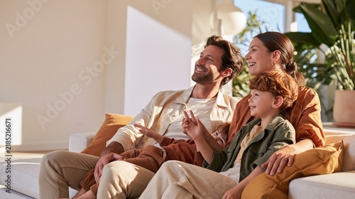 Happy family of three relaxing together on sofa in bright sunny living room