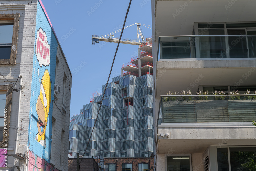 Obraz premium donut shop and apartment balcony with exterior of KING Toronto Condos designed by Bjarke Ingels Group (BIG) in the area of King W and Portland
