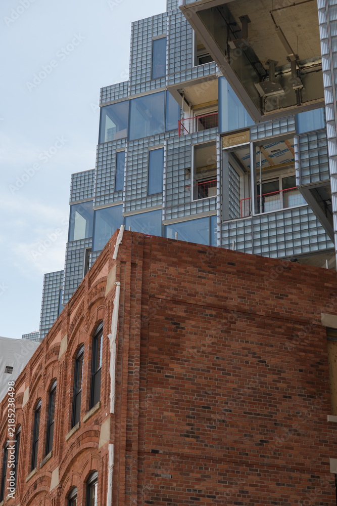 Obraz premium historic brick building contrasted with exterior of KING Toronto Condos designed by Bjarke Ingels Group (BIG) in the area of King W and Portland