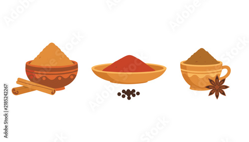 Collection of aromatic spices including cinnamon sticks, star anise, and peppercorns in ceramic bowls.