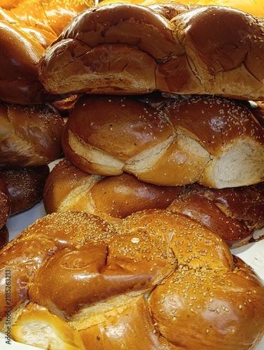 Market stall display with traditional challah bread, braided Shabbat loaves, and Jewish egg bread for sale.