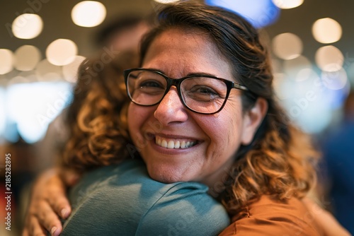 Longtime friends embracing with joyful tears at airport reunion