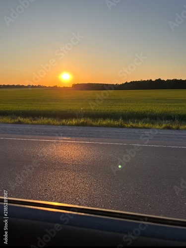 sunset on the road
quiet asphalt road next to a green field under a bright sunset.