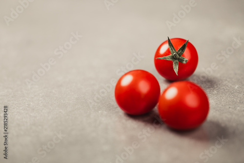 Foto Fresh red cherry tomatoes on neutral stone background with copy space