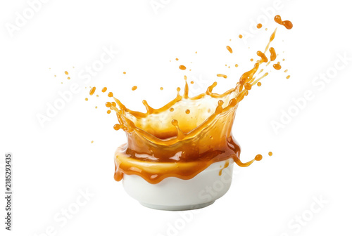 Caramel sauce splashing from a white ceramic bowl isolated on black background