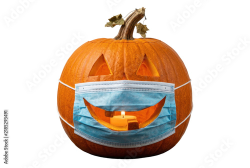 Carved orange pumpkin wearing a blue face mask for autumn holiday