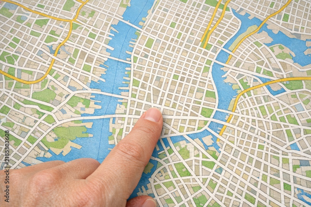 Obraz premium A person pointing on a map of a city, ideal for use in travel or real estate projects