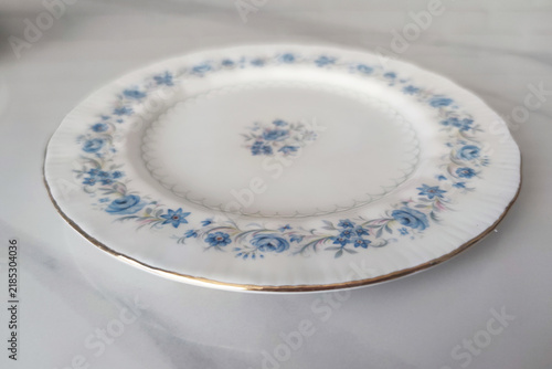 vintage porcelain plate with blue floral pattern and gold rim