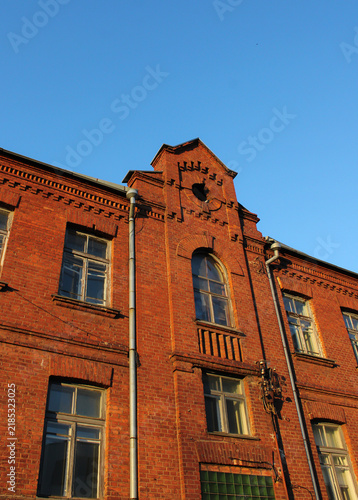 Bild auf Leinwand Architectural detail of an old red brick building facade with a decorative pedim