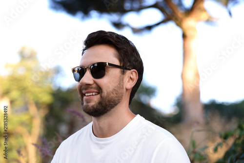 Handsome man wearing stylish sunglasses in park
