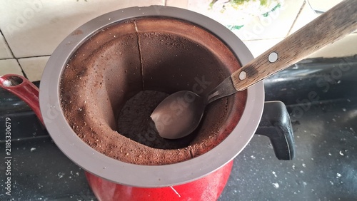 Quadro su tela Traditional fabric coffee strainer sitting inside a vibrant red metal pot