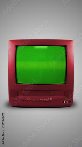 Old red TV on a light background with a green screen. CRT screen of a vintage TV. Vertical looping animation.