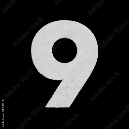 White crumpled paper cutout of the number nine isolated on a black background