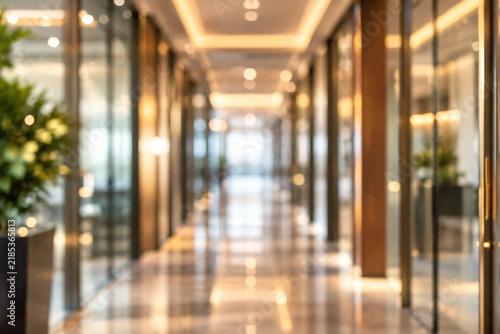 An abstract out-of-focus background of a modern luxury office hallway with warm lighting.