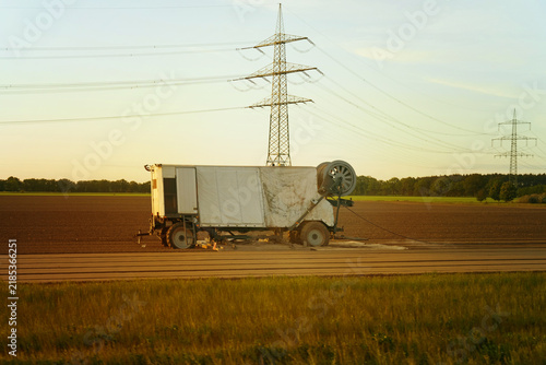 Abandoned vehicle under the golden sunset in a vast field