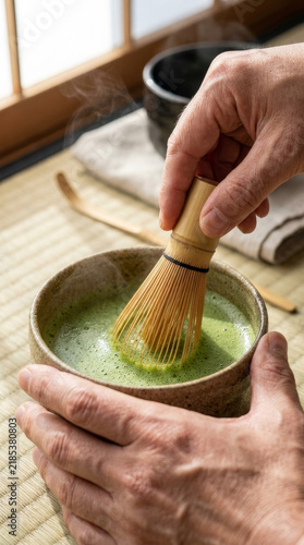 Hand whisking matcha tea in a traditional Japanese tea setting  