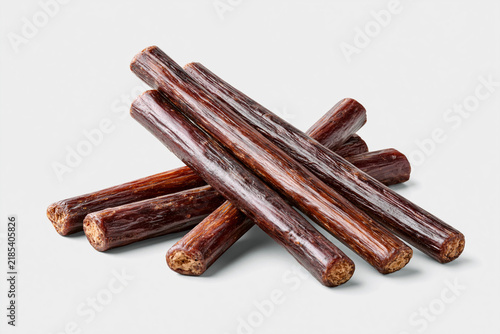 Beef sticks arranged in a pile on a plain background