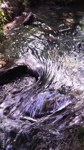 Zoom In on Fast Flowing River Water Rushing over Rocks and Boulders