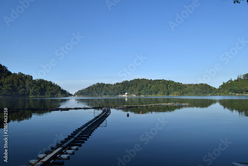 A beautiful lake on a bright morning, featuring clear water and a stunning blue sky