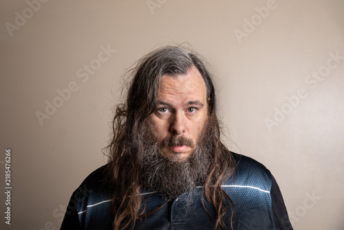 Portrait of a man with long, wavy hair and full beard