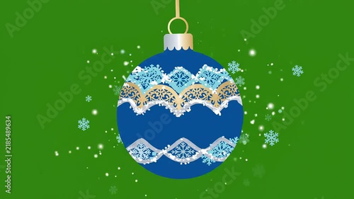 Blue and gold decorative Christmas bauble ornament hanging with falling snowflakes on green background. Perfect for holiday video projects, seasonal greeting cards or background design.