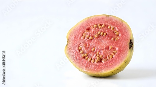 Fresh pink guava half sliced open showing yellow skin and seeds on white background