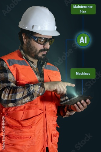 An industrial worker monitors an industrial process using his tablet and with the help of artificial intelligence