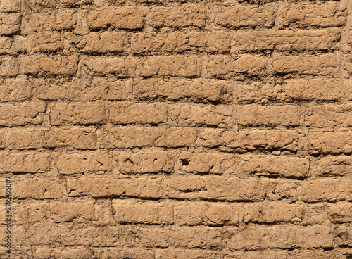 Foto Old adobe brick wall texture with natural earthen surface and rustic brown tones