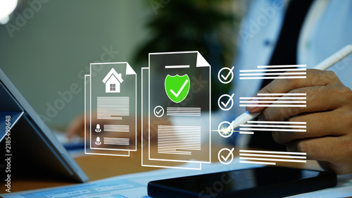 Obraz na płótnie Holographic digital home insurance approval on tablet, Businessman using a stylus and tablet with virtual documents home icon shield and check marks for online insurance, approval and data protection