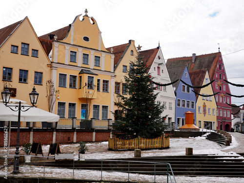Foto A decorated Christmas tree stands in a snow-dusted town square framed by colourf
