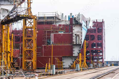Canvastavla Complex internal structure of a giant ship hull section under construction, with steel frames, beams and reinforced compartments visible at a shipyard