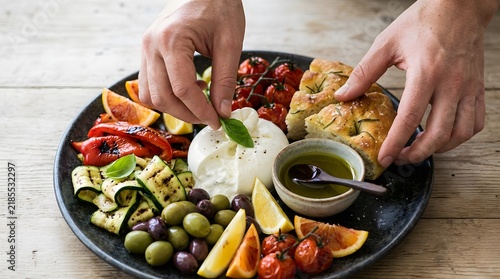 Chef plating fresh Mediterranean burrata cheese appetizer platter.