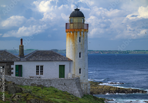 OLD SCOTISH LIGHTHOUSE WITH A DOME AND RUST STREAKS WITH A ATTACHED BUILDING ON THE ISLE OF MAY IN THE NORTH SEA