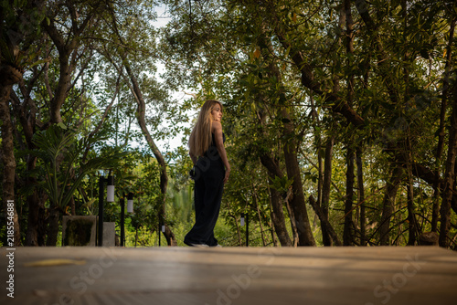 A woman stands in the middle of a mangrove forest.