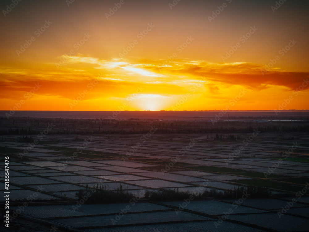 Fototapeta premium Aerial view near Guazhou Service Area Gansu sunset glow over gobi desert with power transmission towers and highway