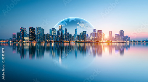 A futuristic city skyline reflects on calm water with a glowing Earth image hovering above, highlighting urban innovation and global connectivity at sunset.