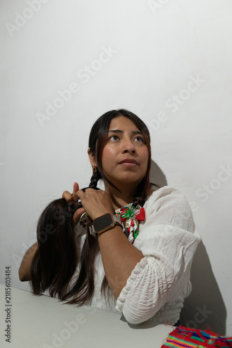 Canvastavla Mexican woman braiding her long dark hair, celebrating traditional culture and i