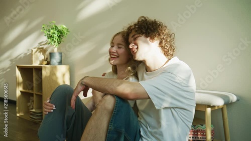 Couple sits together in a cozy room filled with light and plants while sharing a moment of connection and conversation during the afternoon