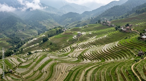 Lush Green Rice Terraces Carved into Mountainside with Traditional Villages and Misty Peaks