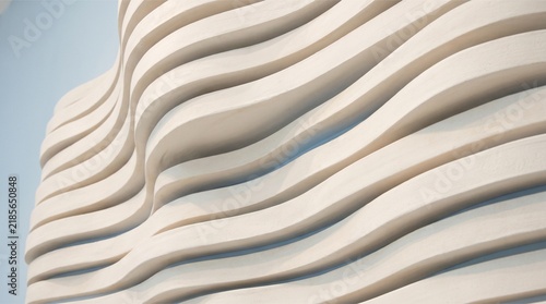 Abstract architectural facade with modern wavy white concrete lines and geometric curves.