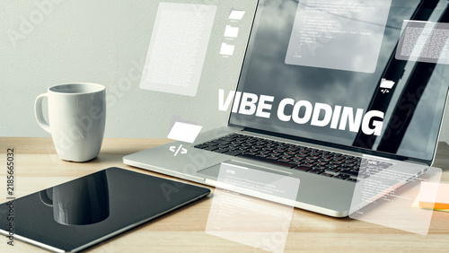 Fotografie Working on vibe coding at a desk with a laptop, coffee, and tablet during the da