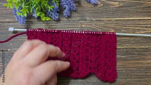 Multicolored hand-knitted fabric. Knitting and crochet lessons. Fashion and education. Training for artificial intelligence. Hands in the frame.