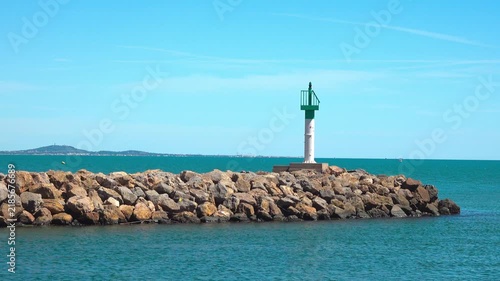 Lighthouse on the pier by the water. Valras, France .