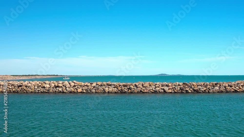 Boats are near a breakwater in open water. Valras, France .