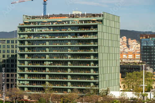 Modern eco-friendly office building with green facade and rooftop terrace in Poblenou 22@ tech district, Barcelona, Spain. Sustainable commercial real estate, business center, urban infrastructure