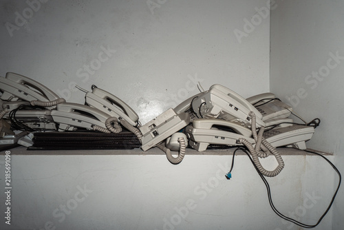 Pile of vintage telephones in dimly lit room