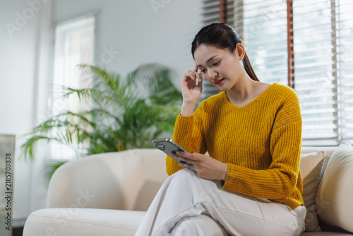 Woman experiencing stress using smartphone at home
