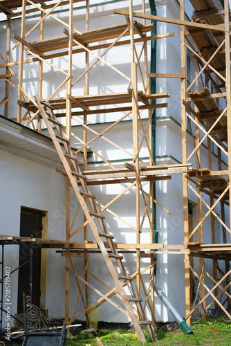 Foto Wooden construction scaffolding with ladder installed around a building facade d