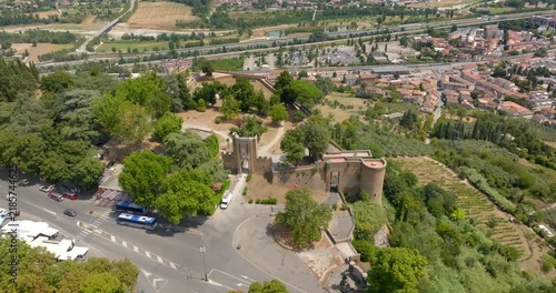 Aerial view of the entrance building of the Pozzo di San Patrizio well in Orvieto, in the province of Terni, Umbria, Italy, overlooking a road roundabout, olive tree terraces, and the valley below.