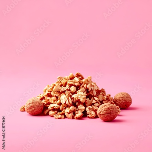 Walnuts pile on soft pink background